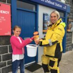 Donaghadee RNLI crew member Rebecca receiving a donation of £136.57